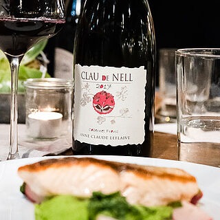 Eine Rotweinflasche auf einem gedeckten Tisch