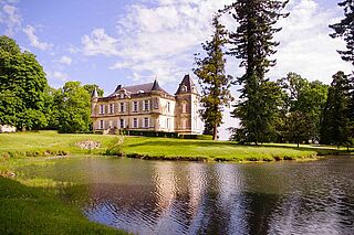 Anwesen des Weinguts Mauvasin Barton vor einem See