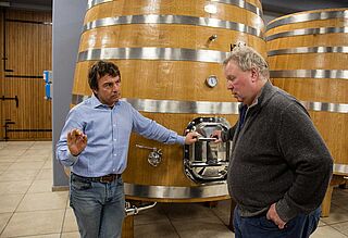 Roberto Conterno und Heiner Lobenberg im Weinkeller mit Weinfässern