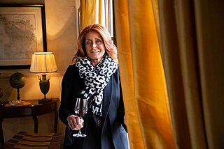 Elisabett Gepetti mit einem Rotweinglas in der Hand in einem Raum auf dem Weingut Le Pupille