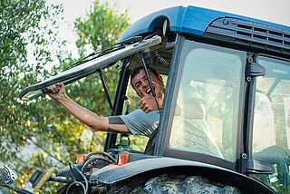 Mann in einem Traktor bei der Arbeit auf dem Weinfeld la Follonica Mann in einem Traktor bei der Arbeit auf dem Weinfeld la Follonica