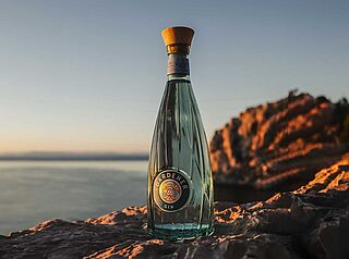 Eine Flasche Gin an der Küste