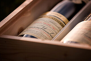 Weinflaschen der Domaine Weinbach in einer Holzkiste